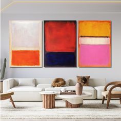 a living room with three paintings on the wall