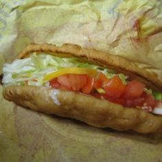 a hot dog with lettuce, tomatoes and onions