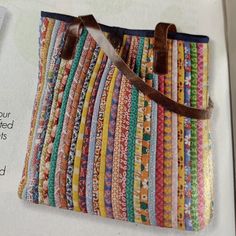 an open book with a bag made out of strips of fabric on the front and side