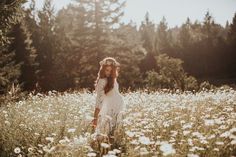 a woman is standing in the middle of a field