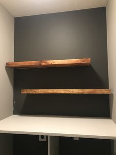 two wooden shelves on the wall in a room