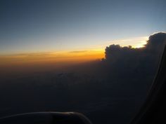 the view from an airplane window at sunset