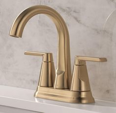 a gold faucet on a white counter top