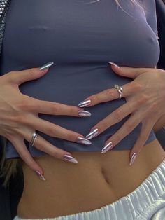 a woman with long nails and silver manies on her belly