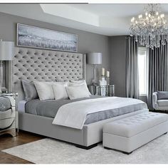 a bedroom with a large bed and chandelier