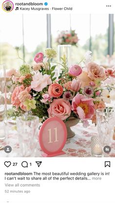 a vase filled with pink flowers on top of a table next to glasses and candles