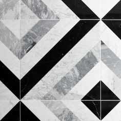 a black and white tiled floor with an abstract design in the middle that looks like it is made out of marble