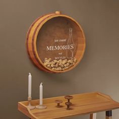 there is a wooden barrel on the wall next to candles and a bottle that says, we count memories and bottles