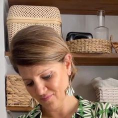 a woman is looking at her cell phone in front of some baskets and wickers