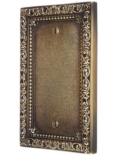 an antique brass plate with ornate designs on the front and back side, isolated against a white background