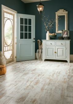 a room with blue walls and white furniture in front of the door is decorated with flowers