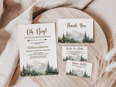 the wedding stationery is set on top of a wooden table