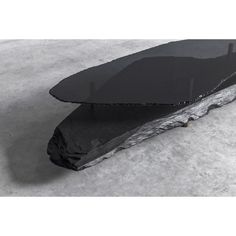 a piece of black stone sitting on top of snow covered ground