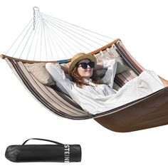 a woman laying in a hammock with sunglasses on