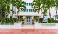 the entrance to an apartment building with palm trees