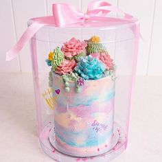 there is a cake in the shape of a box with flowers on it and a pink bow