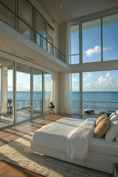 a bedroom with large windows overlooking the ocean