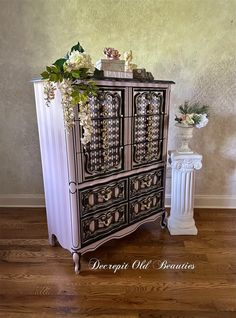 a white and black cabinet sitting on top of a hard wood floor