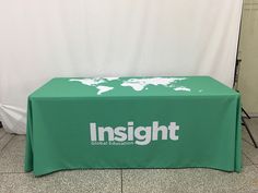 a green table with the words insight on it and a world map behind it