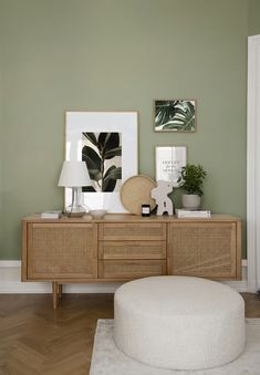 a living room with green walls and white rug on the floor next to an ottoman