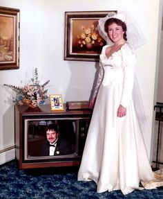 a woman in a wedding dress standing next to a tv with the caption tell me this isn't a popularity contest contest