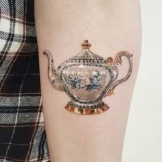 a woman's leg with a tattoo of a teapot on it