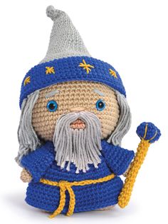 a small crocheted toy with a blue hat and grey beard holding a yellow stick