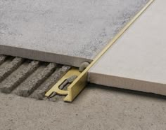 a close up of a cement slab with a yellow handle on the ground next to it