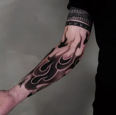 a man's arm is covered in black and white ink with flames on it