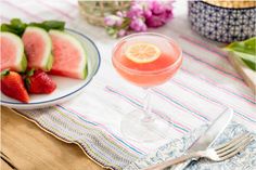 a plate with watermelon slices on it next to a glass filled with liquid