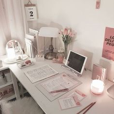 a white desk topped with lots of papers and a laptop computer