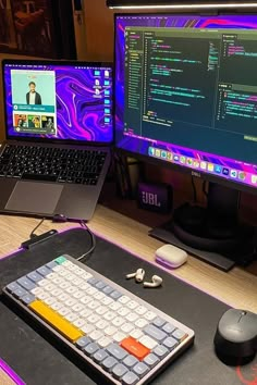 two computer monitors sitting on top of a desk next to a keyboard and mouse pad