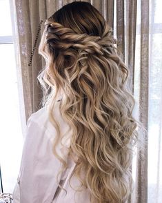 the back of a woman's head with long blonde hair and braid in it