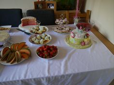 a table topped with lots of different types of cakes and desserts on plates next to each other