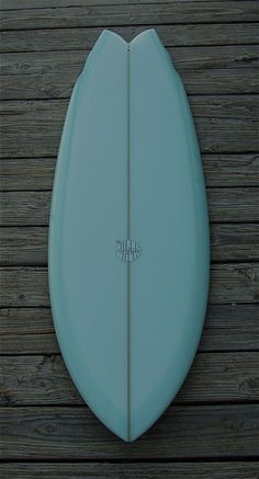 a blue surfboard sitting on top of a wooden floor