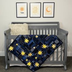 a baby crib with a quilt and two pictures on the wall