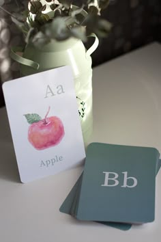 two cards with the letters a, b and c on them next to a potted plant