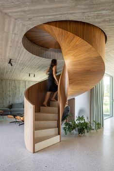 a woman is walking up the stairs in a house with wooden walls and flooring