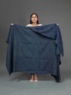 a woman is holding up a blue blanket