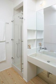 a bathroom with a sink, mirror and shower stall in the middle of the room