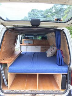 the back end of a van with a bed in it