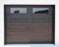 a garage door with two windows and bars on the side