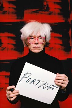 an older man with white hair and glasses holding up a piece of paper that says portraits