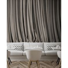 an elegant living room with white furniture and gray drapes on the wall, along with chevron wood flooring