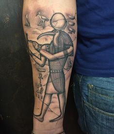 an egyptian style tattoo on the arm of a man holding a bow and arrow in his right hand