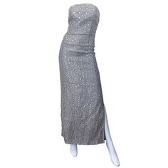 Magnifique robe de soirée bustier vintage des années 90 en soie gris argenté avec paillettes Elle présente un corsage ajusté et désossé, avec une fermeture éclair cachée dans le dos et une fermeture à crochets et à œillets. La fente sur la jambe gauche révèle juste la bonne quantité de peau. Une beauté classique à l'élégance discrète. Très bien fait, avec une telle attention aux détails. En très bon état. Taille marquée US 6 Mesures : 17-18 pouces de l'aisselle à l'aisselle (sans bretelles) tail Silver Dress Wedding, Strapless Evening Dress, Boned Bodice, Gray Silk, Vintage Gowns, Formal Outfits, Silver Dress, Dress Gown, Gown Dress