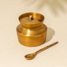 a brass container with a spoon next to it