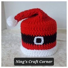 a crocheted red and black hat with white trim