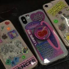 three iphone cases with stickers on them sitting next to each other in the same case