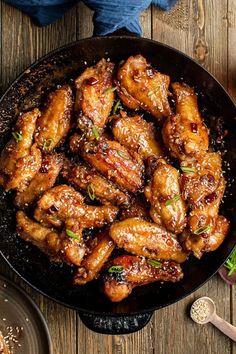 chicken wings in a skillet on a wooden table